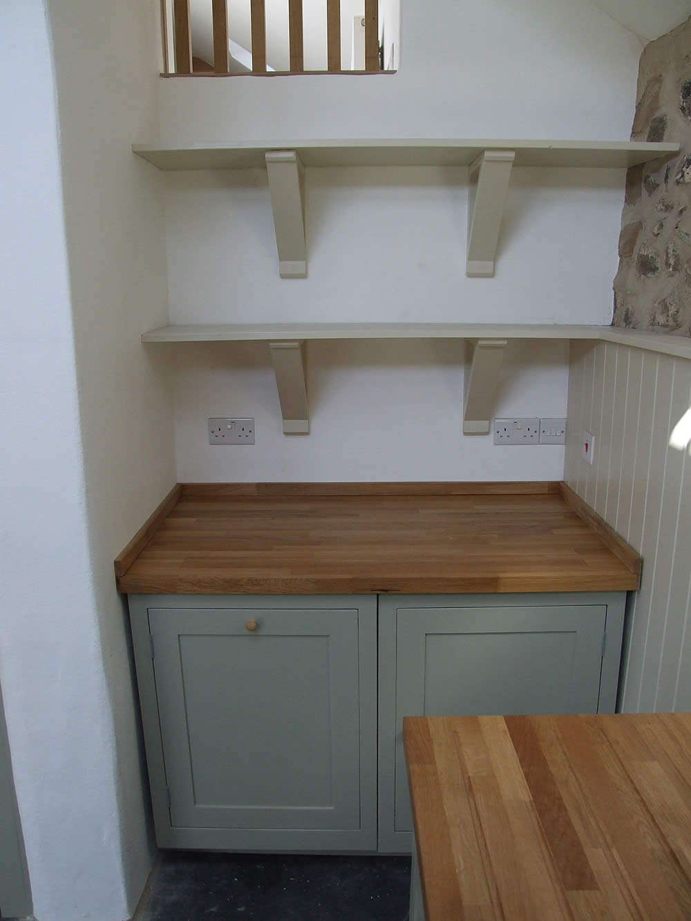 Detail of the painted Shaker kitchen showing the integrated appliance doors & gallows bracket painted shelves
